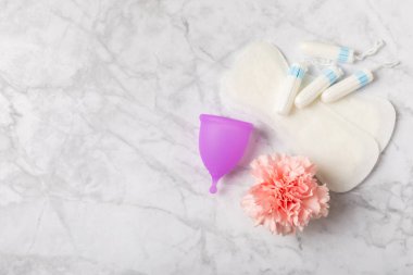 Aybaşı bardağı parlak bir arka planda. Hijyenik peçeteler, tamponlar ve regl kupası. Kritik günler, regl dönemi kavramı. Kadın hijyen ürünü. Kadın sağlığı kavramı. Adet öncesi sendromu. Boşluğu kopyala