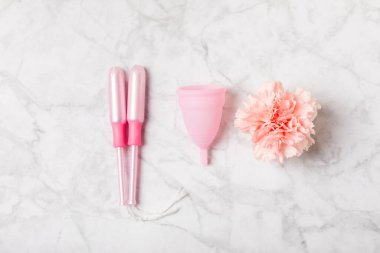 Aybaşı bardağı parlak bir arka planda. Hijyenik peçeteler, tamponlar ve regl kupası. Kritik günler, regl dönemi kavramı. Kadın hijyen ürünü. Kadın sağlığı kavramı. Adet öncesi sendromu. Boşluğu kopyala