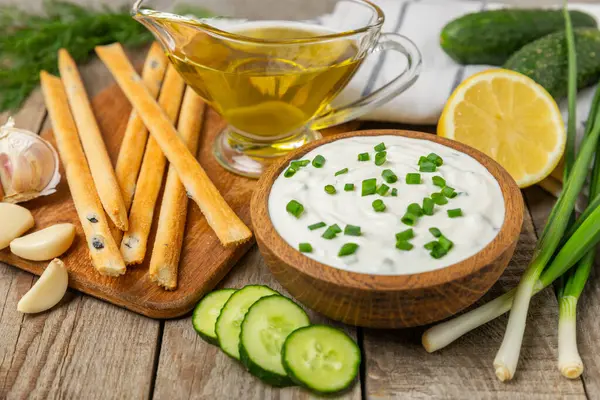 Ahşap bir masada salatalık kremalı tzatziki sosu. Tatar sosu. Geleneksel lezzetli aperatif. Yoğurt sosu. Tzatziki, salatalık, sarımsak, dereotu, limon, nane. Salata sosu. Kopya alanı.