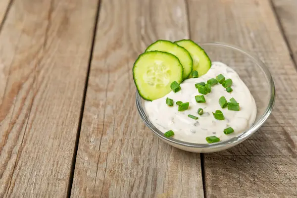 Ahşap bir masada salatalık kremalı tzatziki sosu. Tatar sosu. Geleneksel lezzetli aperatif. Yoğurt sosu. Tzatziki, salatalık, sarımsak, dereotu, limon, nane. Salata sosu. Kopya alanı.