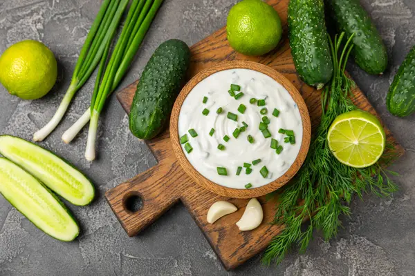 Ahşap bir masada salatalık kremalı tzatziki sosu. Tatar sosu. Geleneksel lezzetli aperatif. Yoğurt sosu. Tzatziki, salatalık, sarımsak, dereotu, limon, nane. Salata sosu. Kopya alanı.
