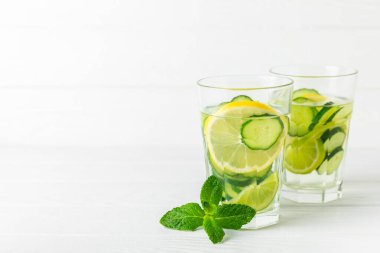 Salatalık suyu, limon, nane ve ahşap bir masada. İçme bardağında dilimlenmiş salatalık ile karıştırılmış su. Tonik ferahlatıcı bir içecek. Salatalık limonata. Doğal soğutma içeceği. Boşluğu kopyala.