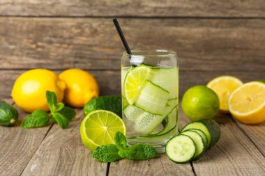 Salatalık suyu, limon, nane ve ahşap bir masada. İçme bardağında dilimlenmiş salatalık ile karıştırılmış su. Tonik ferahlatıcı bir içecek. Salatalık limonata. Doğal soğutma içeceği. Boşluğu kopyala.