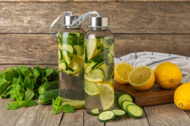 Salatalık suyu, limon, nane ve ahşap bir masada. İçme bardağında dilimlenmiş salatalık ile karıştırılmış su. Tonik ferahlatıcı bir içecek. Salatalık limonata. Doğal soğutma içeceği. Boşluğu kopyala.