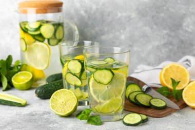 Salatalık suyu, limon, nane ve ahşap bir masada. İçme bardağında dilimlenmiş salatalık ile karıştırılmış su. Tonik ferahlatıcı bir içecek. Salatalık limonata. Doğal soğutma içeceği. Boşluğu kopyala.