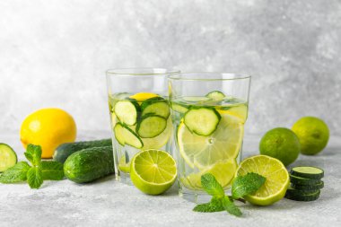 Salatalık suyu, limon, nane ve ahşap bir masada. İçme bardağında dilimlenmiş salatalık ile karıştırılmış su. Tonik ferahlatıcı bir içecek. Salatalık limonata. Doğal soğutma içeceği. Boşluğu kopyala.