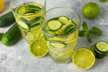 Salatalık suyu, limon, nane ve ahşap bir masada. İçme bardağında dilimlenmiş salatalık ile karıştırılmış su. Tonik ferahlatıcı bir içecek. Salatalık limonata. Doğal soğutma içeceği. Boşluğu kopyala.