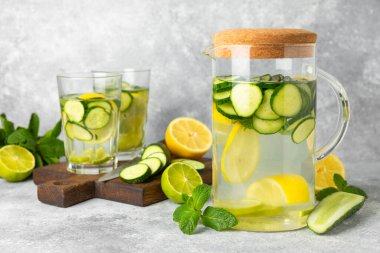Salatalık suyu, limon, nane ve ahşap bir masada. İçme bardağında dilimlenmiş salatalık ile karıştırılmış su. Tonik ferahlatıcı bir içecek. Salatalık limonata. Doğal soğutma içeceği. Boşluğu kopyala.