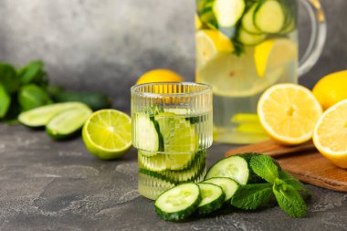 Salatalık suyu, limon, nane ve ahşap bir masada. İçme bardağında dilimlenmiş salatalık ile karıştırılmış su. Tonik ferahlatıcı bir içecek. Salatalık limonata. Doğal soğutma içeceği. Boşluğu kopyala.