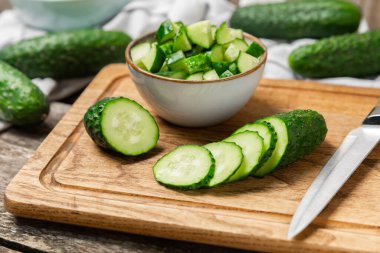 Ahşap arka planda salatalık. Arka planda bir parça salatalık. Taze organik yeşil salatalık turşusu. Vejetaryen. Salata malzemesi. Çiftlik sebzeleri. Sebzeleri bıçakla kes. Mesaj için yer var. Boşluğu kopyala