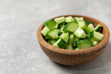 Ahşap arka planda salatalık. Arka planda bir parça salatalık. Taze organik yeşil salatalık turşusu. Vejetaryen. Salata malzemesi. Çiftlik sebzeleri. Sebzeleri bıçakla kes. Mesaj için yer var. Boşluğu kopyala