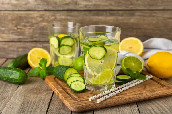 Salatalık suyu, limon, nane ve ahşap bir masada. İçme bardağında dilimlenmiş salatalık ile karıştırılmış su. Tonik ferahlatıcı bir içecek. Salatalık limonata. Doğal soğutma içeceği. Boşluğu kopyala.