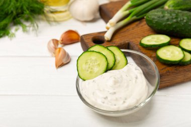 Ahşap bir masada salatalık kremalı tzatziki sosu. Tatar sosu. Geleneksel lezzetli aperatif. Yoğurt sosu. Tzatziki, salatalık, sarımsak, dereotu, limon, nane. Salata sosu. Kopya alanı.