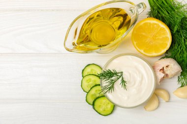 Ahşap bir masada salatalık kremalı tzatziki sosu. Tatar sosu. Geleneksel lezzetli aperatif. Yoğurt sosu. Tzatziki, salatalık, sarımsak, dereotu, limon, nane. Salata sosu. Kopya alanı.