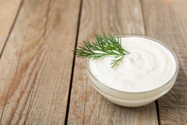 Ahşap bir masada salatalık kremalı tzatziki sosu. Tatar sosu. Geleneksel lezzetli aperatif. Yoğurt sosu. Tzatziki, salatalık, sarımsak, dereotu, limon, nane. Salata sosu. Kopya alanı.