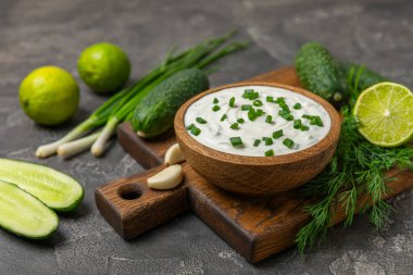 Ahşap bir masada salatalık kremalı tzatziki sosu. Tatar sosu. Geleneksel lezzetli aperatif. Yoğurt sosu. Tzatziki, salatalık, sarımsak, dereotu, limon, nane. Salata sosu. Kopya alanı.