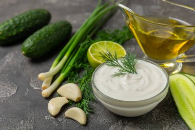 Ahşap bir masada salatalık kremalı tzatziki sosu. Tatar sosu. Geleneksel lezzetli aperatif. Yoğurt sosu. Tzatziki, salatalık, sarımsak, dereotu, limon, nane. Salata sosu. Kopya alanı.