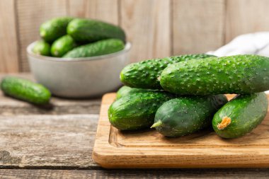 Ahşap arka planda salatalık. Arka planda bir parça salatalık. Taze organik yeşil salatalık turşusu. Vejetaryen. Salata malzemesi. Çiftlik sebzeleri. Sebzeleri bıçakla kes. Mesaj için yer var. Boşluğu kopyala