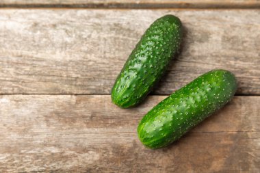 Ahşap arka planda salatalık. Arka planda bir parça salatalık. Taze organik yeşil salatalık turşusu. Vejetaryen. Salata malzemesi. Çiftlik sebzeleri. Sebzeleri bıçakla kes. Mesaj için yer var. Boşluğu kopyala