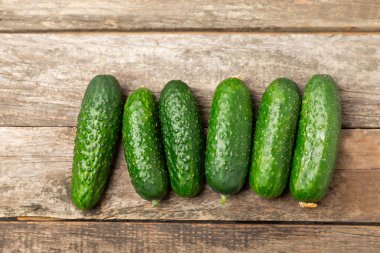 Ahşap arka planda salatalık. Arka planda bir parça salatalık. Taze organik yeşil salatalık turşusu. Vejetaryen. Salata malzemesi. Çiftlik sebzeleri. Sebzeleri bıçakla kes. Mesaj için yer var. Boşluğu kopyala