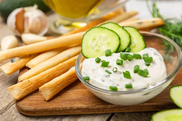 Ahşap bir masada salatalık kremalı tzatziki sosu. Tatar sosu. Geleneksel lezzetli aperatif. Yoğurt sosu. Tzatziki, salatalık, sarımsak, dereotu, limon, nane. Salata sosu. Kopya alanı.
