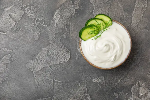 Ahşap bir masada salatalık kremalı tzatziki sosu. Tatar sosu. Geleneksel lezzetli aperatif. Yoğurt sosu. Tzatziki, salatalık, sarımsak, dereotu, limon, nane. Salata sosu. Kopya alanı.