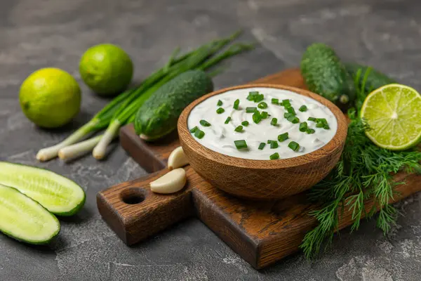 Ahşap bir masada salatalık kremalı tzatziki sosu. Tatar sosu. Geleneksel lezzetli aperatif. Yoğurt sosu. Tzatziki, salatalık, sarımsak, dereotu, limon, nane. Salata sosu. Kopya alanı.