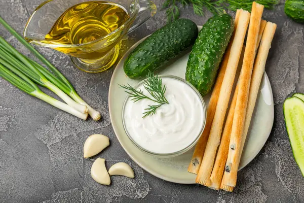 Ahşap bir masada salatalık kremalı tzatziki sosu. Tatar sosu. Geleneksel lezzetli aperatif. Yoğurt sosu. Tzatziki, salatalık, sarımsak, dereotu, limon, nane. Salata sosu. Kopya alanı.