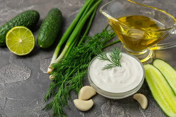 Ahşap bir masada salatalık kremalı tzatziki sosu. Tatar sosu. Geleneksel lezzetli aperatif. Yoğurt sosu. Tzatziki, salatalık, sarımsak, dereotu, limon, nane. Salata sosu. Kopya alanı.