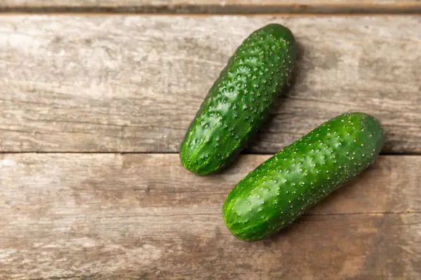 Ahşap arka planda salatalık. Arka planda bir parça salatalık. Taze organik yeşil salatalık turşusu. Vejetaryen. Salata malzemesi. Çiftlik sebzeleri. Sebzeleri bıçakla kes. Mesaj için yer var. Boşluğu kopyala