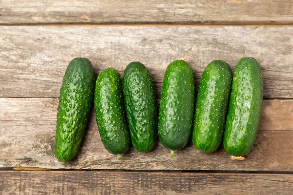 Ahşap arka planda salatalık. Arka planda bir parça salatalık. Taze organik yeşil salatalık turşusu. Vejetaryen. Salata malzemesi. Çiftlik sebzeleri. Sebzeleri bıçakla kes. Mesaj için yer var. Boşluğu kopyala