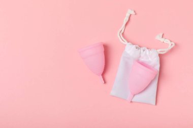 Aybaşı bardağı parlak bir arka planda. Hijyenik peçeteler, tamponlar ve regl kupası. Kritik günler, regl dönemi kavramı. Kadın hijyen ürünü. Kadın sağlığı kavramı. Adet öncesi sendromu. Boşluğu kopyala