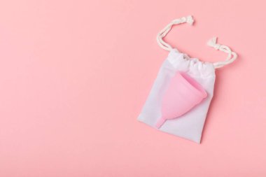 Aybaşı bardağı parlak bir arka planda. Hijyenik peçeteler, tamponlar ve regl kupası. Kritik günler, regl dönemi kavramı. Kadın hijyen ürünü. Kadın sağlığı kavramı. Adet öncesi sendromu. Boşluğu kopyala