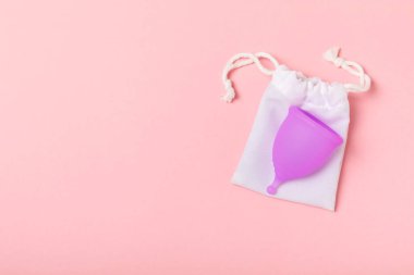 Aybaşı bardağı parlak bir arka planda. Hijyenik peçeteler, tamponlar ve regl kupası. Kritik günler, regl dönemi kavramı. Kadın hijyen ürünü. Kadın sağlığı kavramı. Adet öncesi sendromu. Boşluğu kopyala