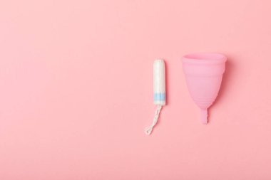 Aybaşı bardağı parlak bir arka planda. Hijyenik peçeteler, tamponlar ve regl kupası. Kritik günler, regl dönemi kavramı. Kadın hijyen ürünü. Kadın sağlığı kavramı. Adet öncesi sendromu. Boşluğu kopyala