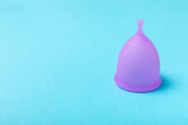 Aybaşı bardağı parlak bir arka planda. Hijyenik peçeteler, tamponlar ve regl kupası. Kritik günler, regl dönemi kavramı. Kadın hijyen ürünü. Kadın sağlığı kavramı. Adet öncesi sendromu. Boşluğu kopyala