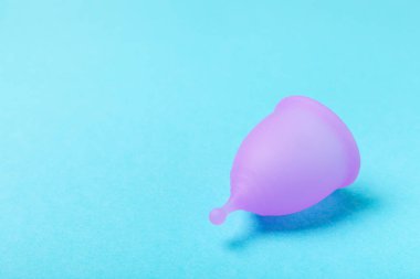 Aybaşı bardağı parlak bir arka planda. Hijyenik peçeteler, tamponlar ve regl kupası. Kritik günler, regl dönemi kavramı. Kadın hijyen ürünü. Kadın sağlığı kavramı. Adet öncesi sendromu. Boşluğu kopyala