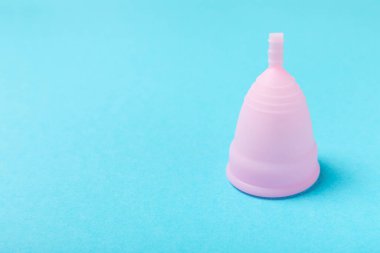 Aybaşı bardağı parlak bir arka planda. Hijyenik peçeteler, tamponlar ve regl kupası. Kritik günler, regl dönemi kavramı. Kadın hijyen ürünü. Kadın sağlığı kavramı. Adet öncesi sendromu. Boşluğu kopyala