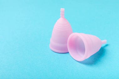 Aybaşı bardağı parlak bir arka planda. Hijyenik peçeteler, tamponlar ve regl kupası. Kritik günler, regl dönemi kavramı. Kadın hijyen ürünü. Kadın sağlığı kavramı. Adet öncesi sendromu. Boşluğu kopyala