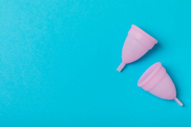 Aybaşı bardağı parlak bir arka planda. Hijyenik peçeteler, tamponlar ve regl kupası. Kritik günler, regl dönemi kavramı. Kadın hijyen ürünü. Kadın sağlığı kavramı. Adet öncesi sendromu. Boşluğu kopyala