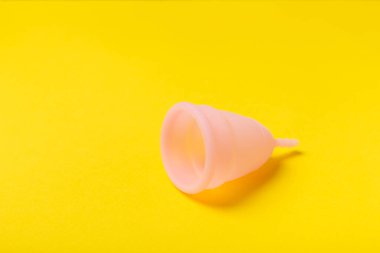 Aybaşı bardağı parlak bir arka planda. Hijyenik peçeteler, tamponlar ve regl kupası. Kritik günler, regl dönemi kavramı. Kadın hijyen ürünü. Kadın sağlığı kavramı. Adet öncesi sendromu. Boşluğu kopyala