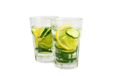 Beyaz arka planda limonlu, limonlu ve naneli salatalık suyu. İçme bardağında dilimlenmiş salatalık ile karıştırılmış su. Tonik ferahlatıcı bir içecek. Salatalık limonata. Doğal soğutma içeceği.