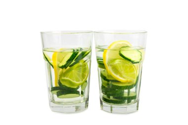 Beyaz arka planda limonlu, limonlu ve naneli salatalık suyu. İçme bardağında dilimlenmiş salatalık ile karıştırılmış su. Tonik ferahlatıcı bir içecek. Salatalık limonata. Doğal soğutma içeceği.