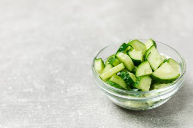 Ahşap arka planda salatalık. Arka planda bir parça salatalık. Taze organik yeşil salatalık turşusu. Vejetaryen. Salata malzemesi. Çiftlik sebzeleri. Sebzeleri bıçakla kes. Mesaj için yer var. Boşluğu kopyala