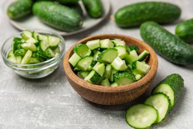 Ahşap arka planda salatalık. Arka planda bir parça salatalık. Taze organik yeşil salatalık turşusu. Vejetaryen. Salata malzemesi. Çiftlik sebzeleri. Sebzeleri bıçakla kes. Mesaj için yer var. Boşluğu kopyala