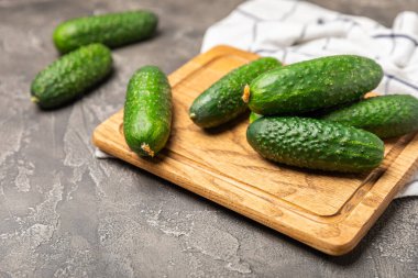 Ahşap arka planda salatalık. Arka planda bir parça salatalık. Taze organik yeşil salatalık turşusu. Vejetaryen. Salata malzemesi. Çiftlik sebzeleri. Sebzeleri bıçakla kes. Mesaj için yer var. Boşluğu kopyala