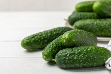 Ahşap arka planda salatalık. Arka planda bir parça salatalık. Taze organik yeşil salatalık turşusu. Vejetaryen. Salata malzemesi. Çiftlik sebzeleri. Sebzeleri bıçakla kes. Mesaj için yer var. Boşluğu kopyala