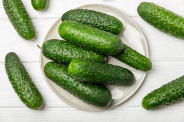 Ahşap arka planda salatalık. Arka planda bir parça salatalık. Taze organik yeşil salatalık turşusu. Vejetaryen. Salata malzemesi. Çiftlik sebzeleri. Sebzeleri bıçakla kes. Mesaj için yer var. Boşluğu kopyala