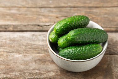 Ahşap arka planda salatalık. Arka planda bir parça salatalık. Taze organik yeşil salatalık turşusu. Vejetaryen. Salata malzemesi. Çiftlik sebzeleri. Sebzeleri bıçakla kes. Mesaj için yer var. Boşluğu kopyala