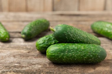 Ahşap arka planda salatalık. Arka planda bir parça salatalık. Taze organik yeşil salatalık turşusu. Vejetaryen. Salata malzemesi. Çiftlik sebzeleri. Sebzeleri bıçakla kes. Mesaj için yer var. Boşluğu kopyala